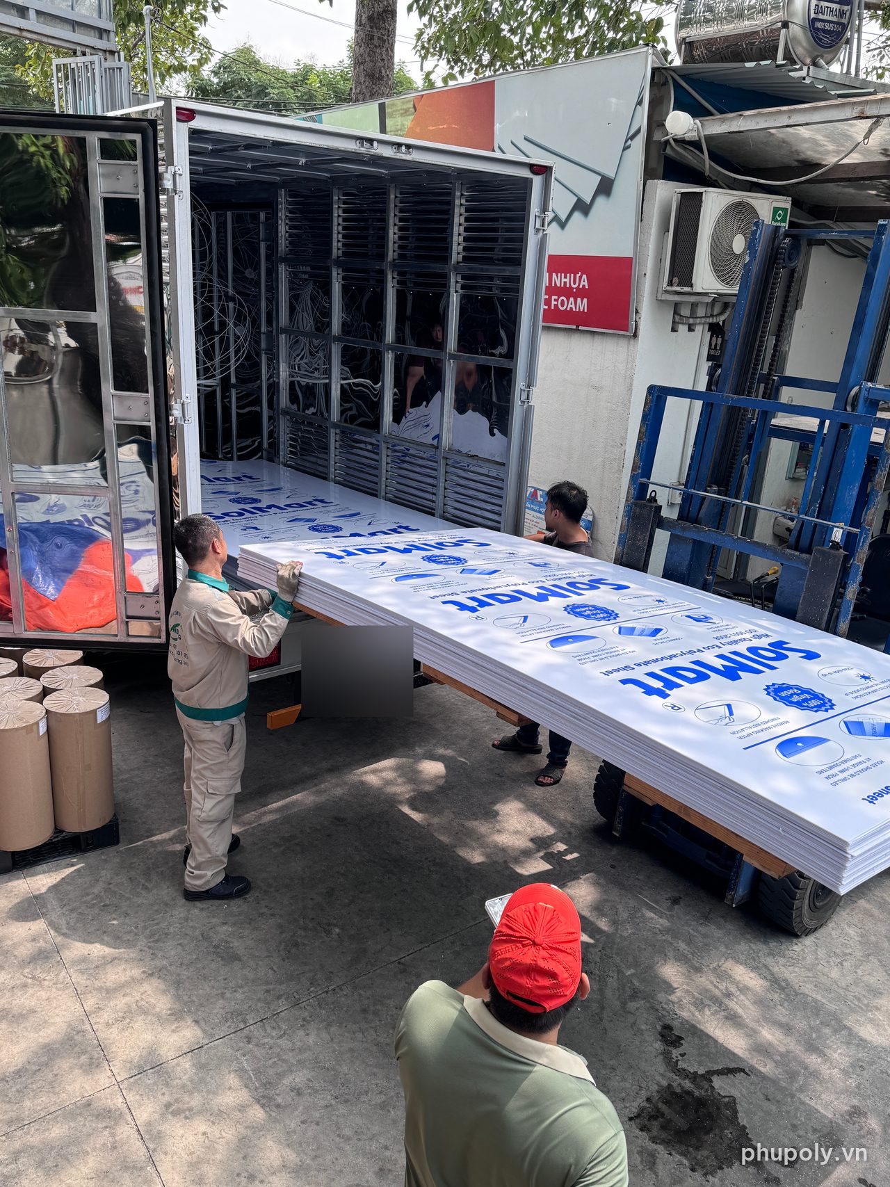 Xe nâng đưa chồng tấm poly đặc SolMart trắng sữa đã cắt lên xe tải tại kho