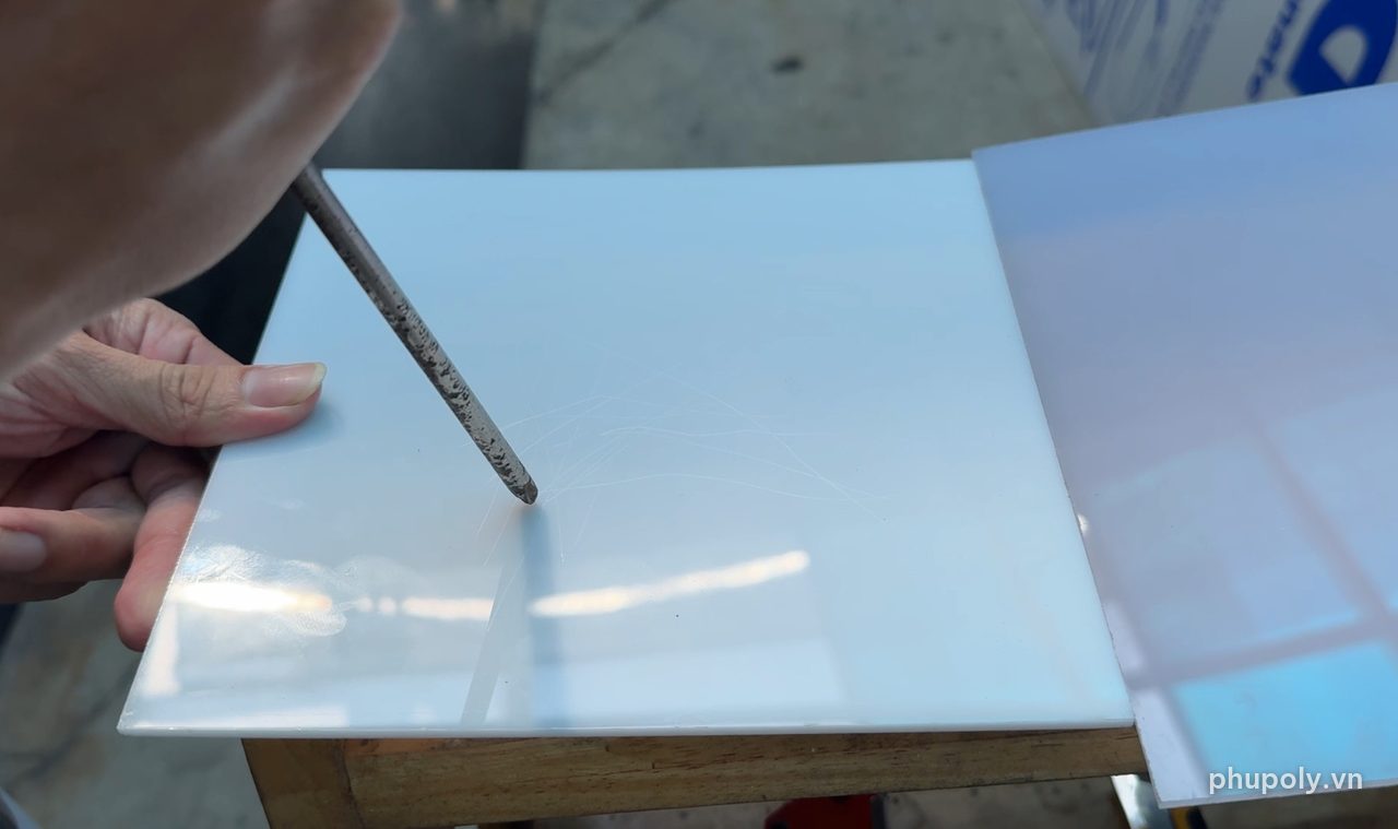 Cào mũi thép nhọn lên mặt tấm mica sữa 3mm