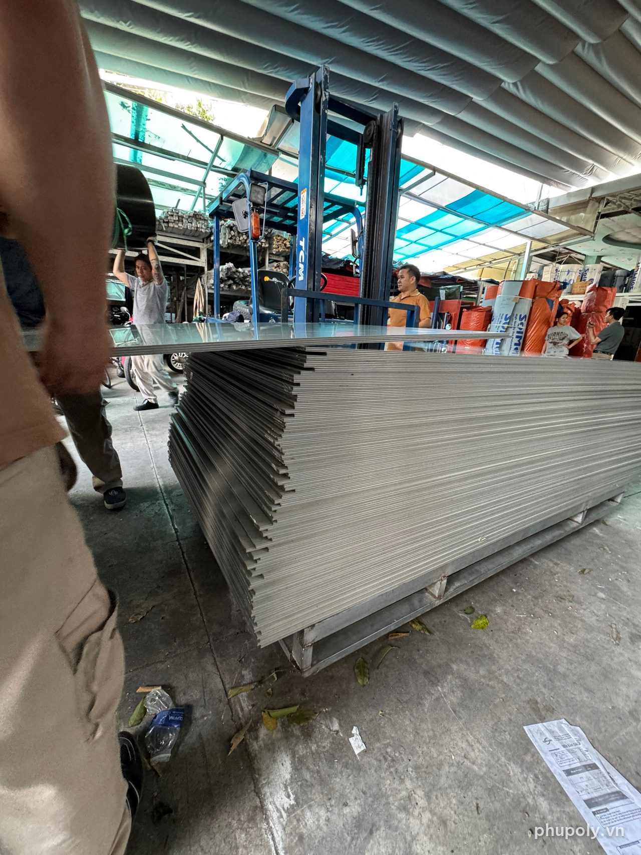 Chồng tấm Alu vừa hạ tại kho Thủ Đức, xe nâng phía sau