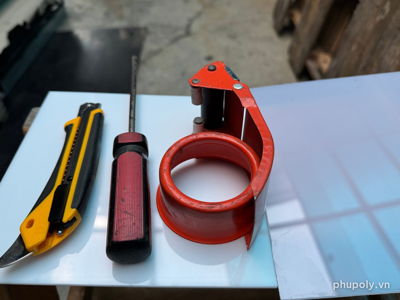 Dao rọc giấy, mũi thép nhọn cán đỏ và cây cắt băng keo dùng để thử trầy, thử cắt