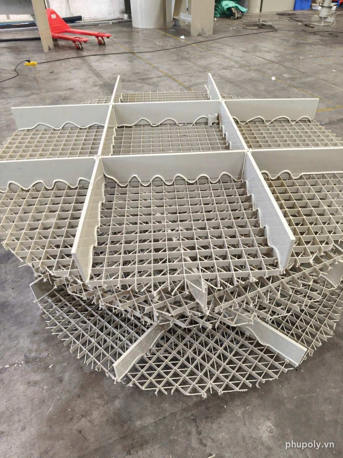 Các tấm khay lưới nhựa PP có khung chia ô xếp chồng trên nền xưởng