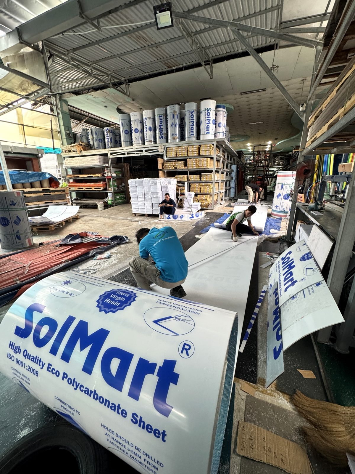 Nhân viên kho Sơn Băng Thủ Đức đo và cắt tấm poly đặc SolMart theo đơn