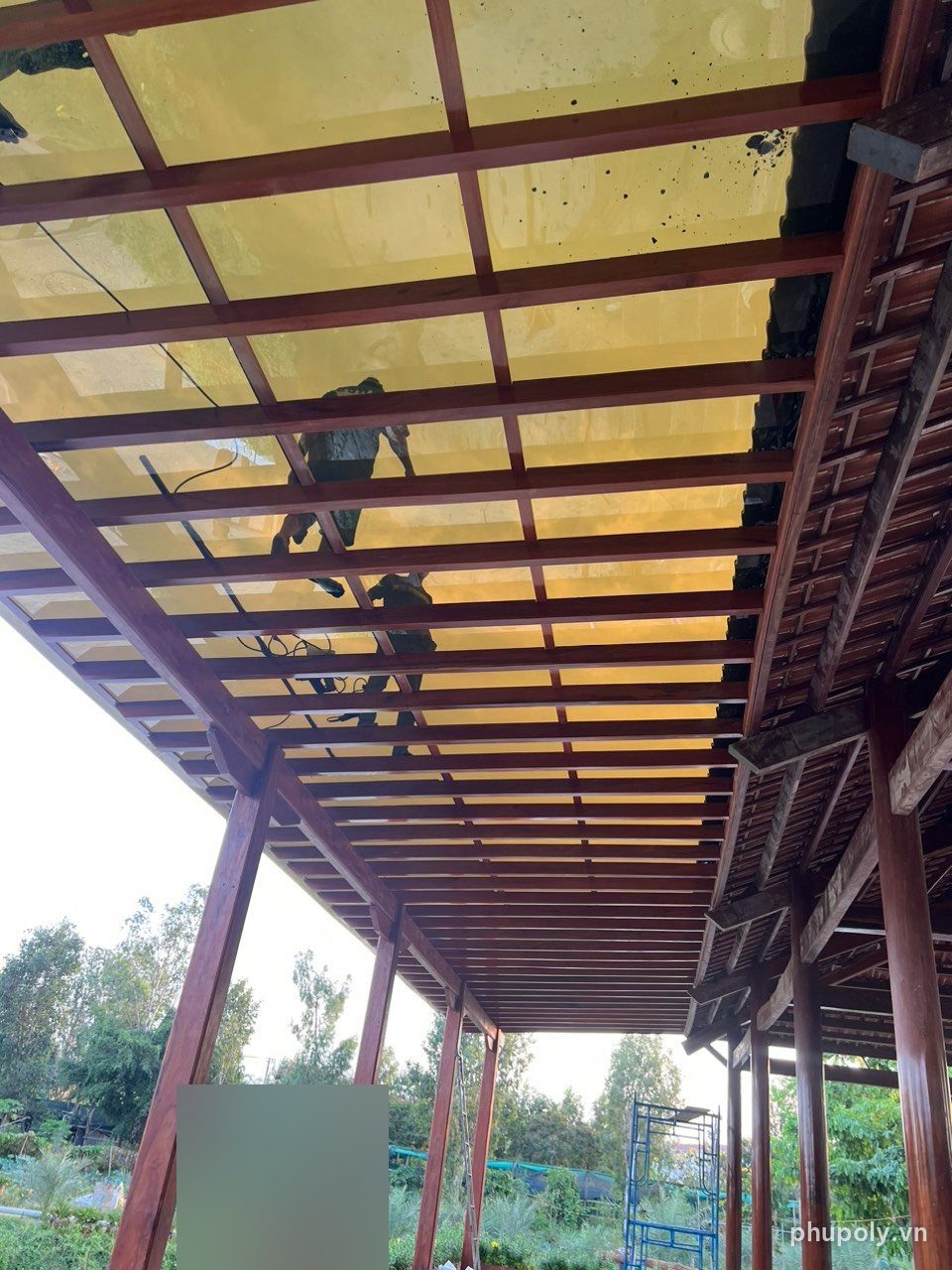 Mái hiên khung gỗ nhà chùa ở Long Khánh lợp poly đặc màu trà 5mm, nhìn từ dưới lên