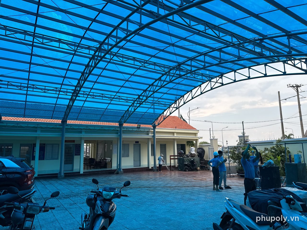 Mái vòm poly đặc SolMart xanh tosca 5mm che sân trụ sở tại Mỹ Tho, nhìn từ sân
