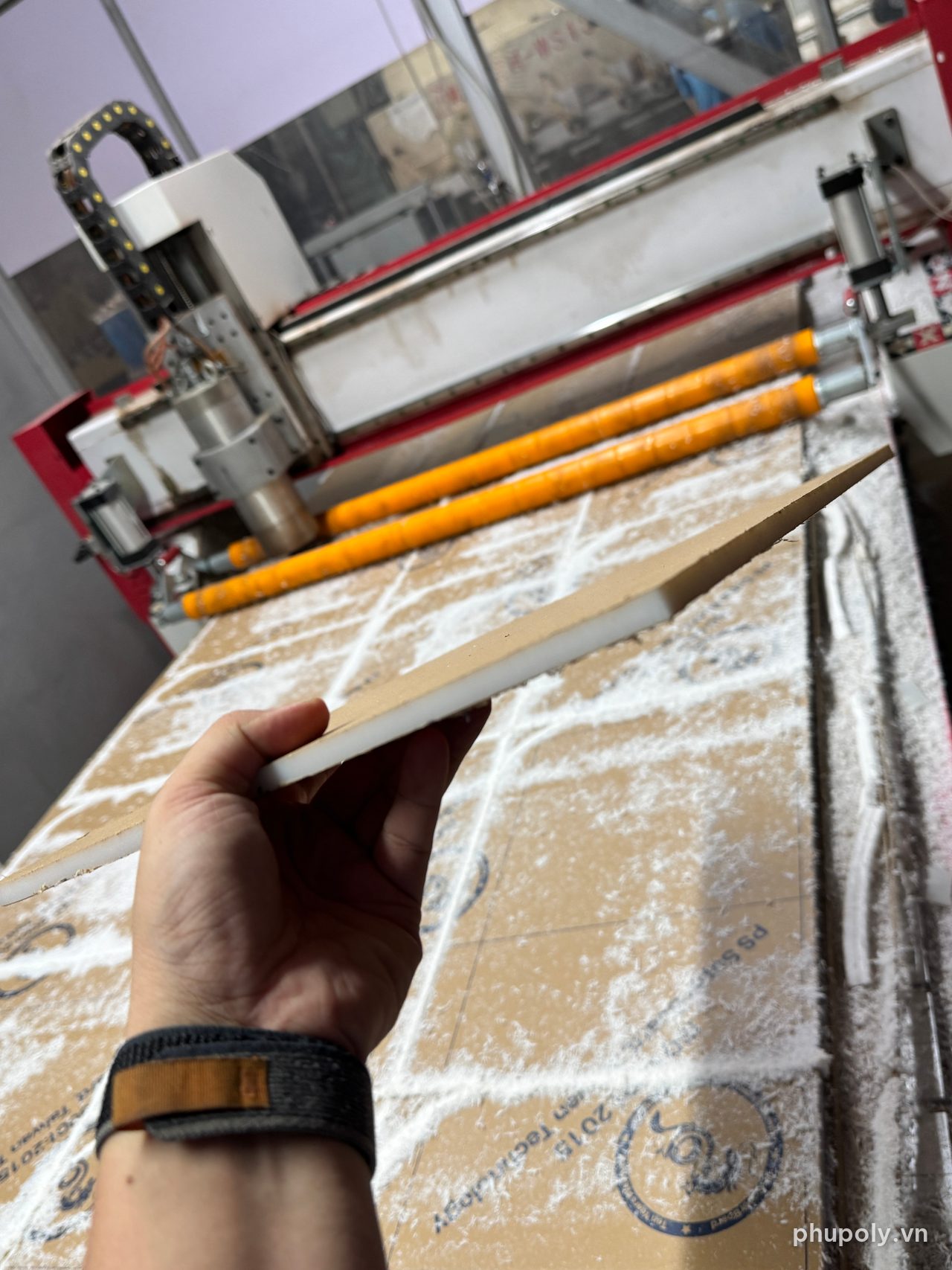 Mép chi tiết mica PS trắng sữa 8mm vừa cắt CNC, tay thợ cầm ngang