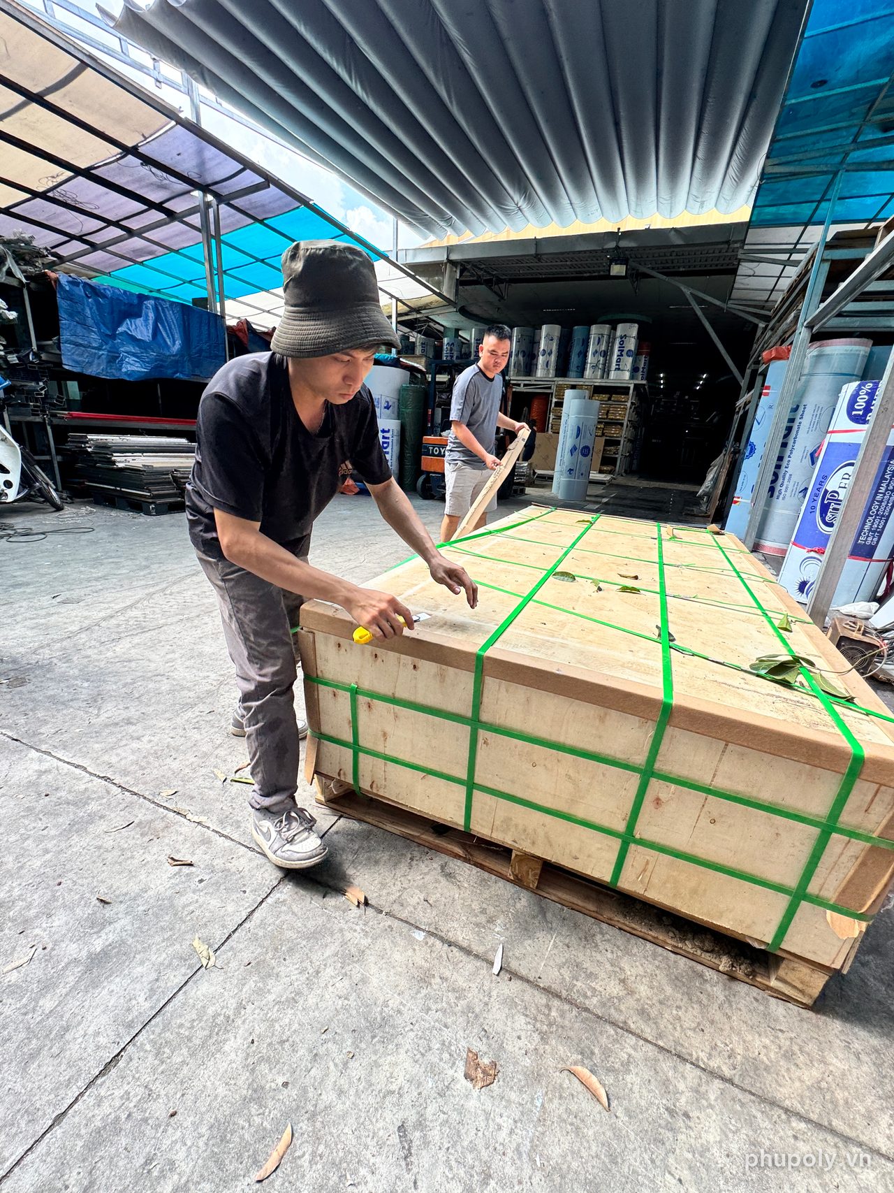 Thợ kho mở kiện gỗ tấm mica tại kho Sơn Băng, Thủ Đức