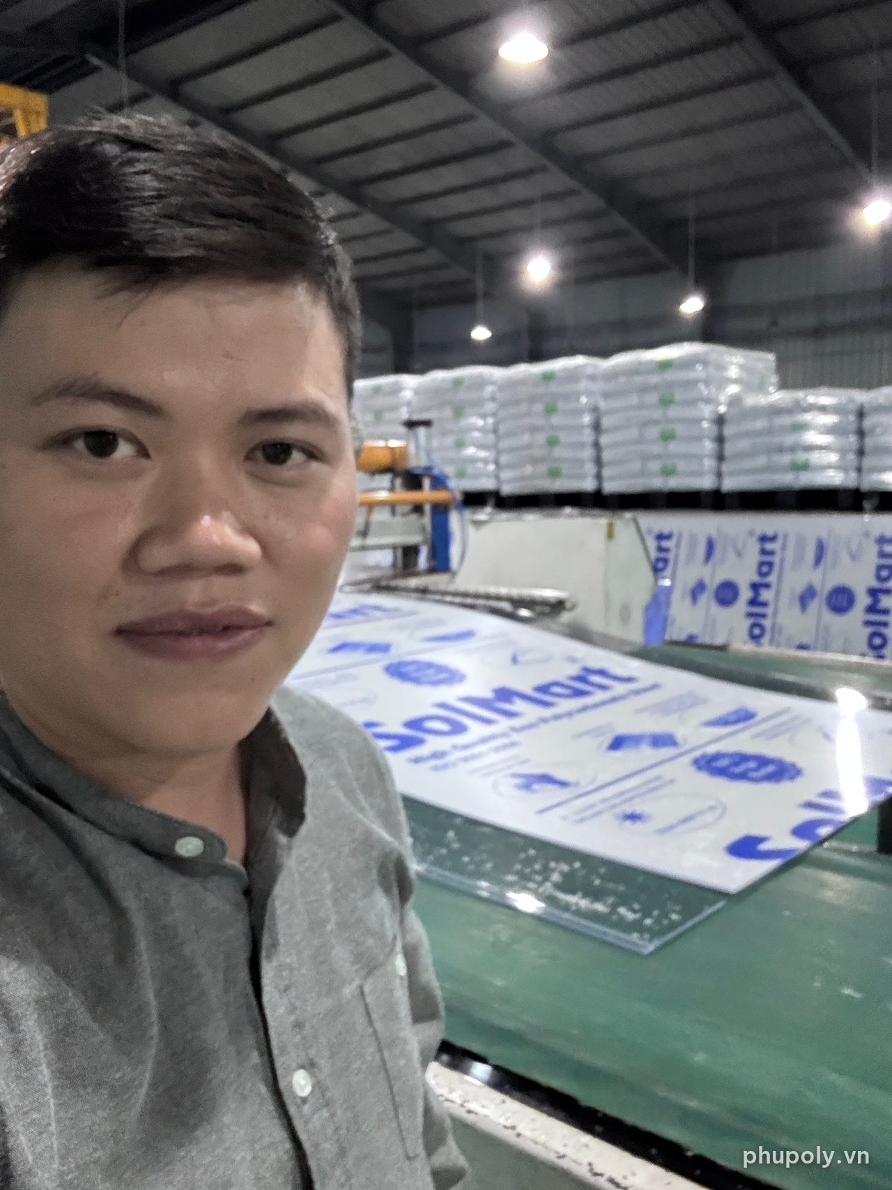 Đinh Bảo Phú đứng bên dây chuyền tấm poly SolMart tại nhà máy Sơn Băng