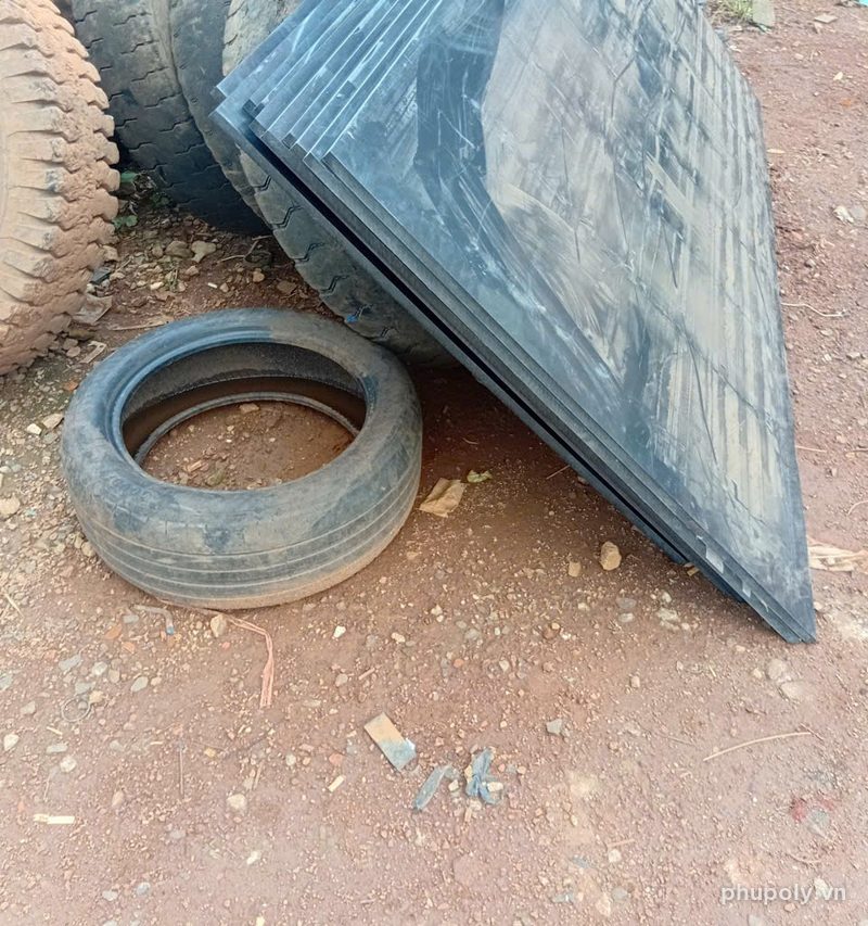 Lô tấm HDPE đen giao tới gara xe, dựng cạnh lốp xe