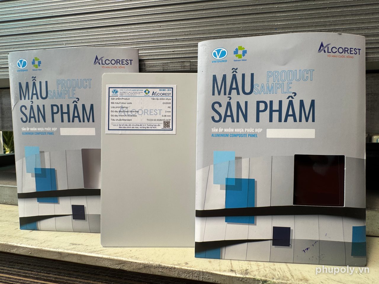Tấm mẫu Alu Alcorest GV2020 lật mặt sau có tem, đứng giữa hai bìa mẫu sản phẩm
