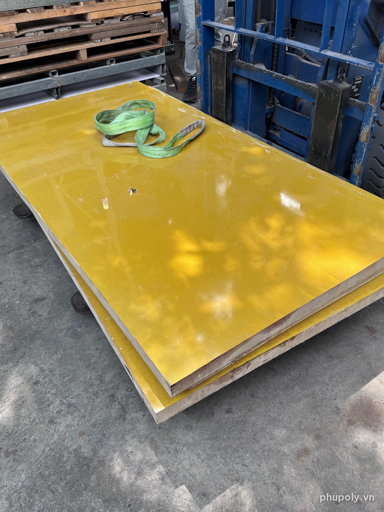 Hai tấm phíp vàng 3240 dày 50mm đặt trên nền kho, có dây cẩu