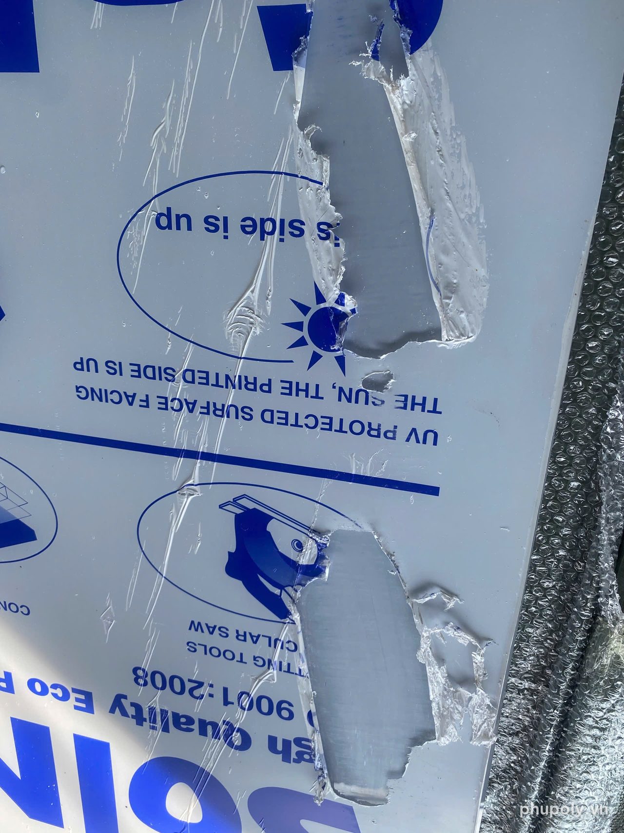 Tấm poly đặc bị xé rách hai mảng lớn trên bề mặt, màng in còn dính