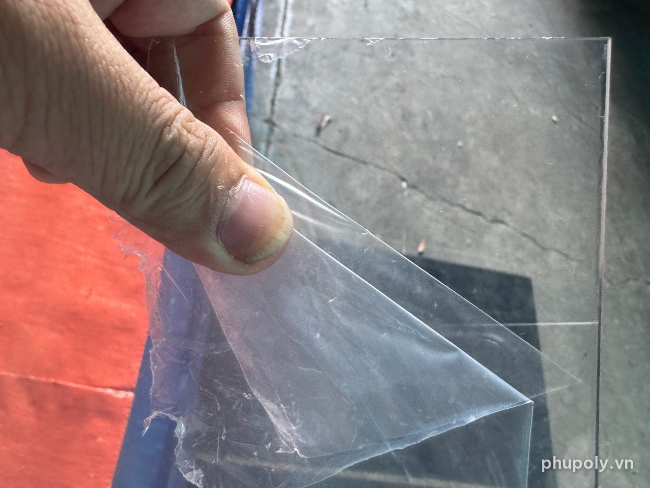 Tay bóc màng nilon khỏi mặt tấm nhựa PE trong suốt 2mm
