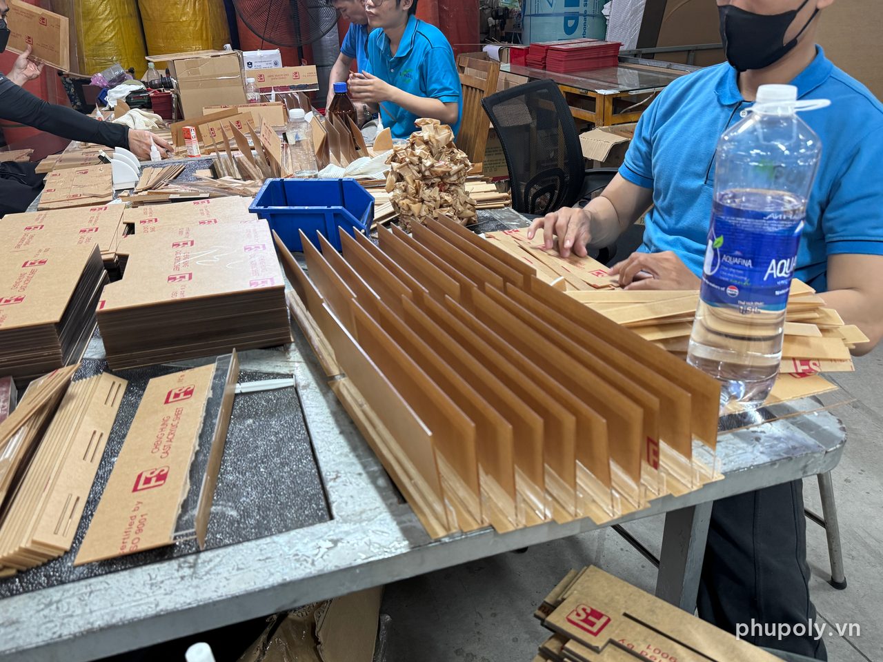 Thợ xưởng Phú Poly ghép vách kệ mica còn giấy bảo vệ trên bàn