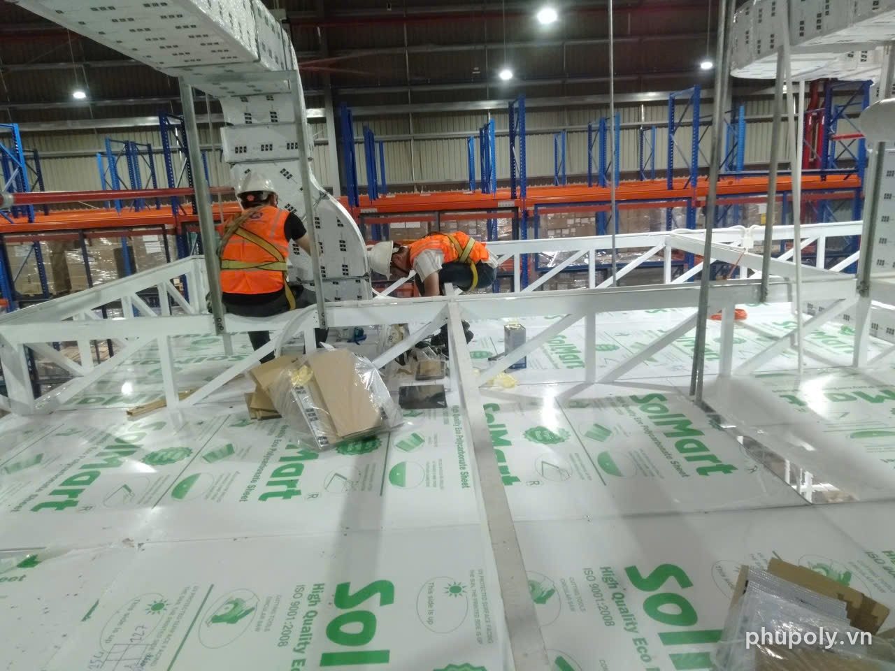 Thợ lợp mái poly đặc SolMart 3 trong 3mm trên khung giàn khu máy trong nhà xưởng