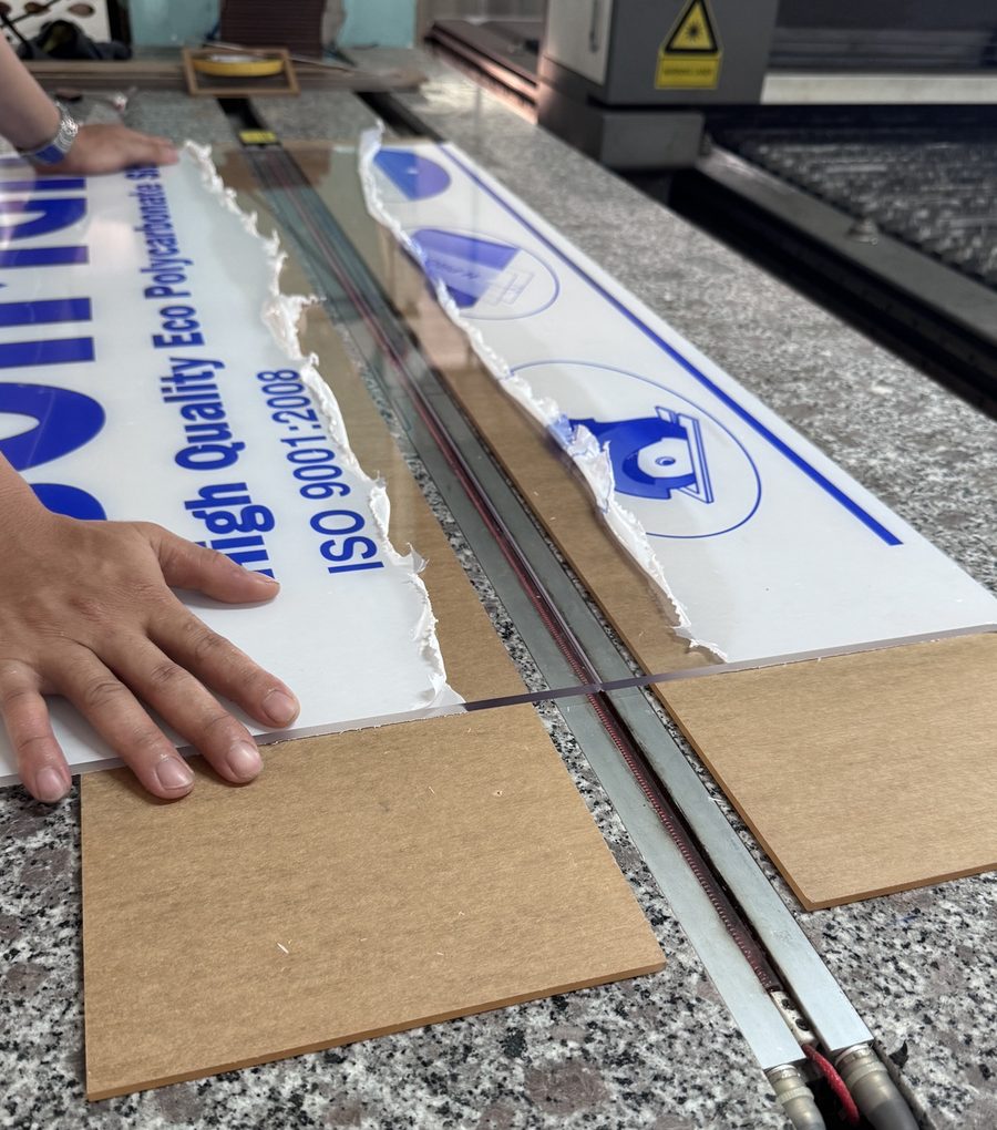 Tấm poly trên bàn uốn nhiệt, màng bảo vệ đã bóc dọc đường uốn