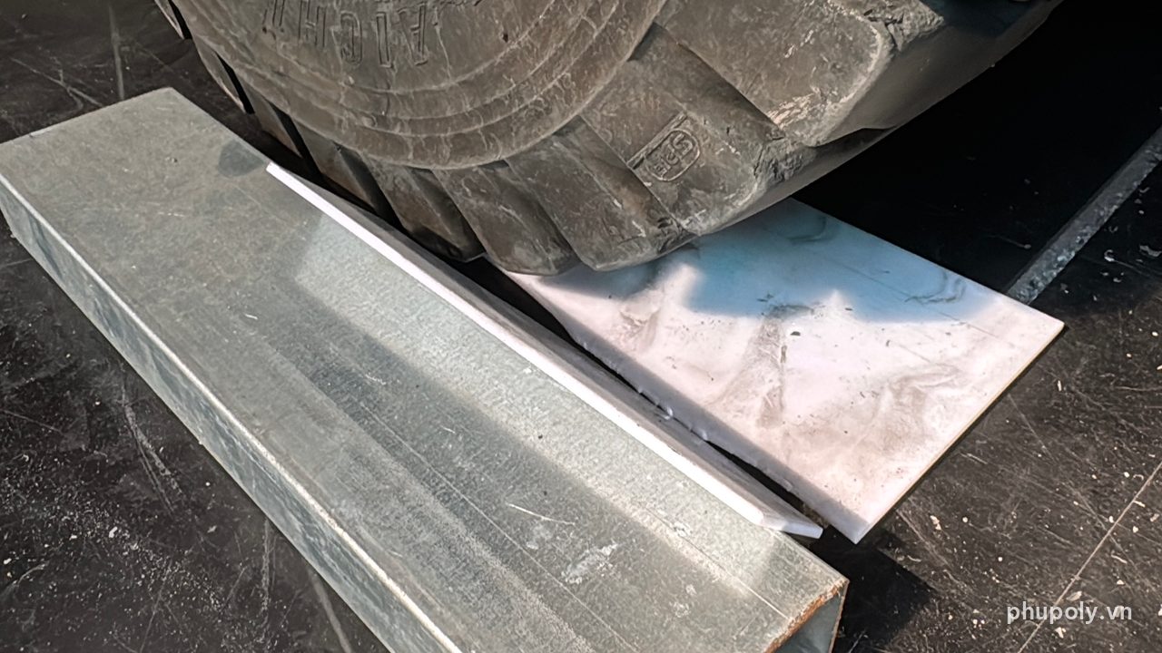 Bánh xe nâng cán lên tấm mica sữa 3mm gác trên thanh thép hộp